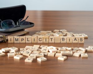 Wooden blocks spell out "Implicit Bias".