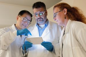 Scientists looking at a tablet