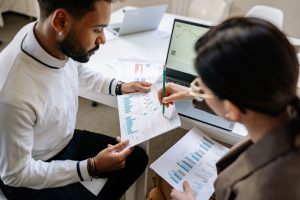 Two people discussing statistical reports