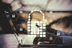 A person using a laptop, with an overlaid image of a graphic representing a lock