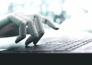 A robotic hand over a computer keyboard