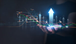 A hand holding upward arrows and graphs with the term “Marketing”